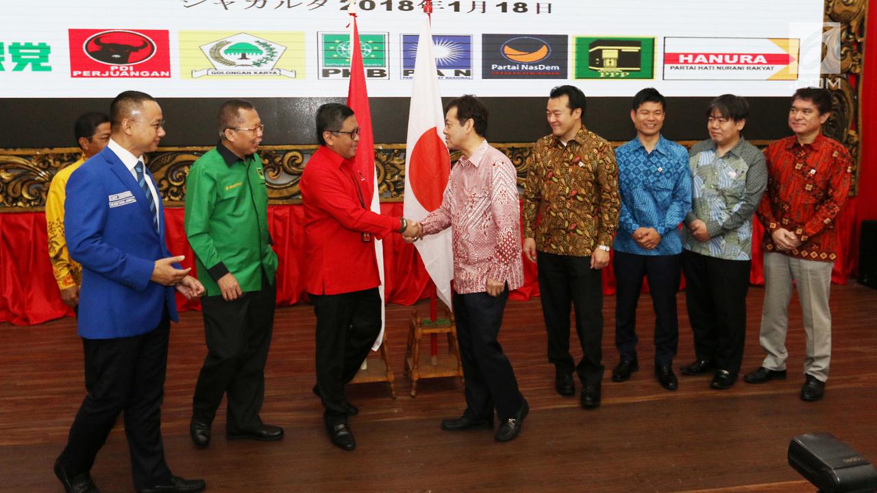 Sekjen PDIP Hasto Kristianto (merah) bersalaman dengan utusan PM Jepang Shinzo Abe di Kantor DPP PDIP, Jakarta. Seluruh utusan PM Jepang mengenakan baju batik dalam pertemuan ini.